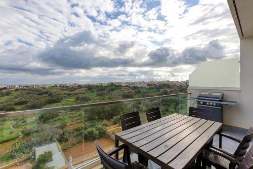 a balcony with a wooden table and chairs at Lovely home with beautiful view with communal pool by 360 Estates in Taʼ Bullara