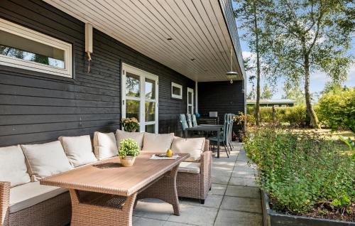 a patio with a couch and a table on a house at Cozy Home In Odder With Wifi in Odder