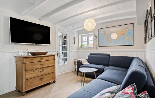 a living room with a blue couch and a tv at Cozy Home In Odder With Wifi in Odder