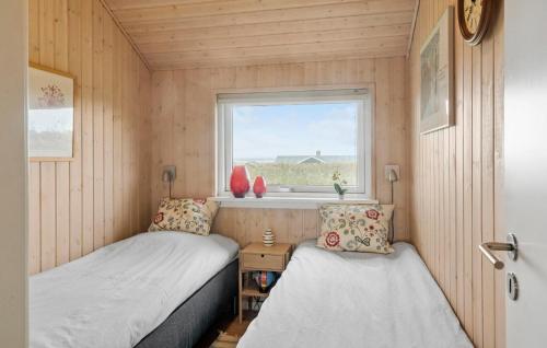 two beds in a small room with a window at Cozy Home In Lemvig With Sauna in Lemvig