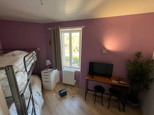 une chambre avec un lit et un bureau avec une télévision dans l'établissement Le Sancy nectaire, à Saint-Nectaire