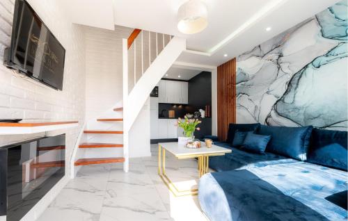 a living room with a blue couch and a marble wall at 2 Bedroom Cozy Home In Sarbinowo in Sarbinowo
