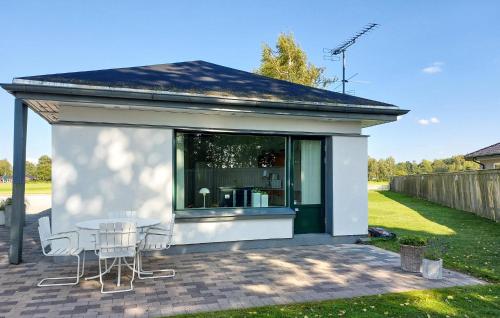 a small white building with a table and chairs at 1 Bedroom Stunning Home In Ludvigsborg in Ludvigsborg