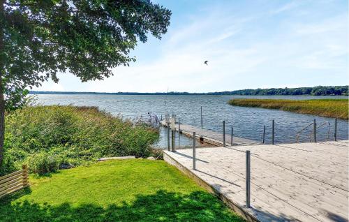 a dock on a lake with a bird flying over it at 1 Bedroom Stunning Home In Ludvigsborg in Ludvigsborg