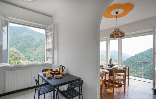 a kitchen and dining room with a table and windows at 3 Bedroom Amazing Apartment In Avegno in Ageno