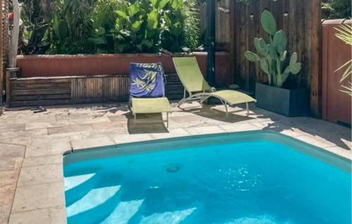 einen Pool mit 2 Stühlen, einem Tisch und einem Stuhl in der Unterkunft 3 Bedroom Stunning Home In Arles in Arles