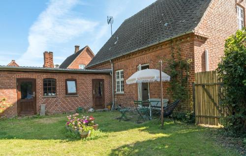Bandholmにある3 Bedroom Awesome Home In Bandholmの庭の傘を持つレンガ造りの家