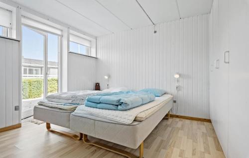a bedroom with a bed with blue pillows on it at 3 Bedroom Stunning Home In Farsø in Farsø
