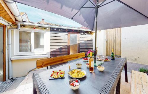 un tavolo con sopra del cibo con un ombrello di Nice Home In Neuville-Sous-Montreuil a Neuville-sous-Montreuil