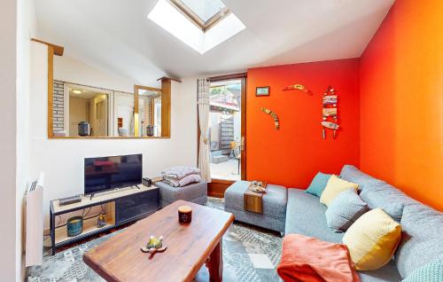 un soggiorno con parete con accento arancione di Nice Home In Neuville-Sous-Montreuil a Neuville-sous-Montreuil