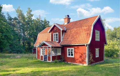 a red house with an orange roof on a field at 3 Bedroom Lovely Home In Högsby in Högsby