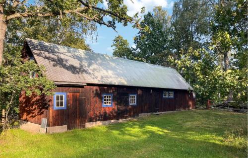a wooden barn with a metal roof in a field at 3 Bedroom Lovely Home In Högsby in Högsby