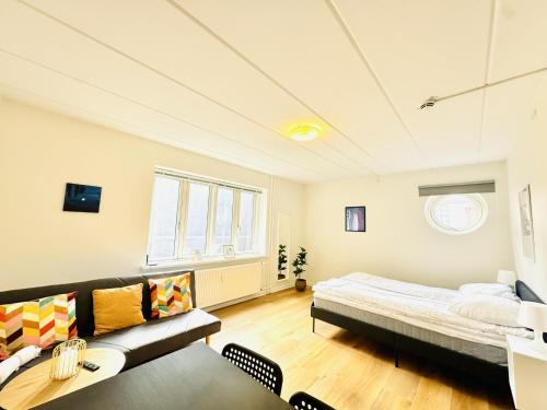 a living room with a bed and a couch at aday - Charming and Bright Studio Apartment in Aalborg