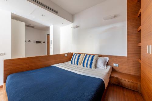 a small bedroom with a blue and white bed at Brera Studio in the heart of Milan in Milan