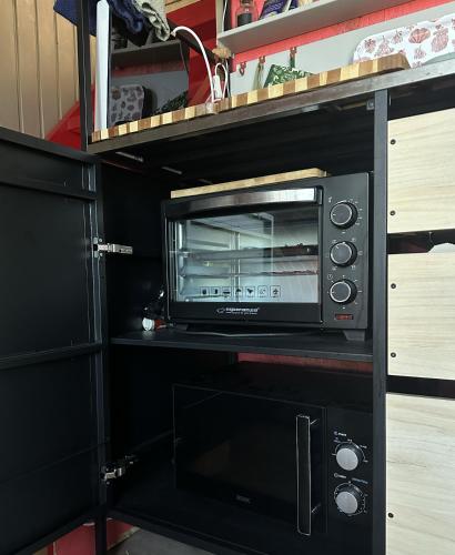 a microwave oven sitting on top of a shelf at Amazing little house on an island with garden in Rīga