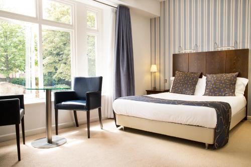 Habitación de hotel con cama y mesa de cristal en Lanes Hotel en Yeovil