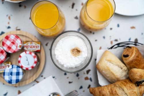 a table with two glasses of orange juice and food at Graphik Montparnasse in Paris