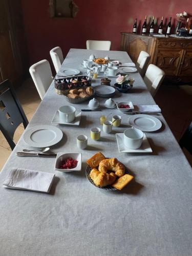 een lange tafel met borden en voedsel erop bij Chateau de GRANDVAUX in Varennes-sous-Dun