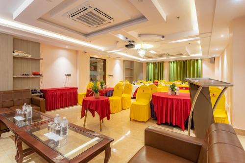 a conference room with tables and yellow chairs at Dream International Hotel in Lumbini