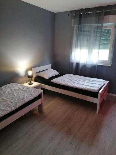 two beds sitting in a room with a window at Landhaus Olive in Čitluk