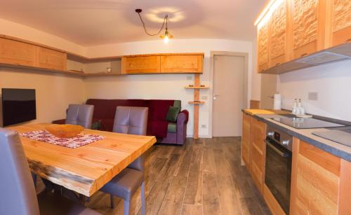 a kitchen and dining room with a wooden table at Ca' di Pazient in Teglio