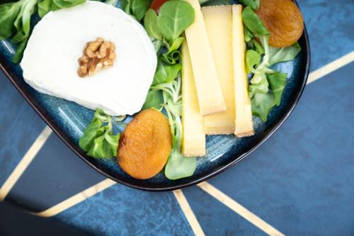 a plate of food with cheese and vegetables on a table at Graphik Montparnasse in Paris
