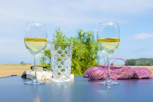 two glasses of white wine sitting on a table at Küstenblick in Carolinensiel