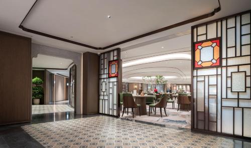 a lobby with a dining room with a table at Yuexiu Hotel Guangzhou,Curio Collection by Hilton-Free shuttle between hotel and Exhibition Center during Canton Fair & Exhibitor Registration Counter in Guangzhou