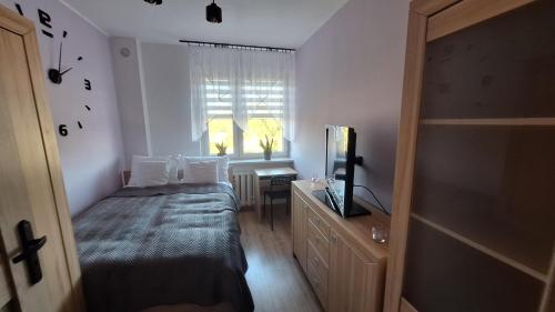Un dormitorio pequeño con una cama y una ventana. en Magmares Apartment, en Bydgoszcz
