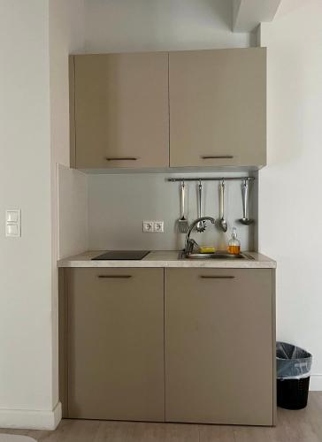 a kitchen with white cabinets and a sink at Maritime Suites in Hersonissos