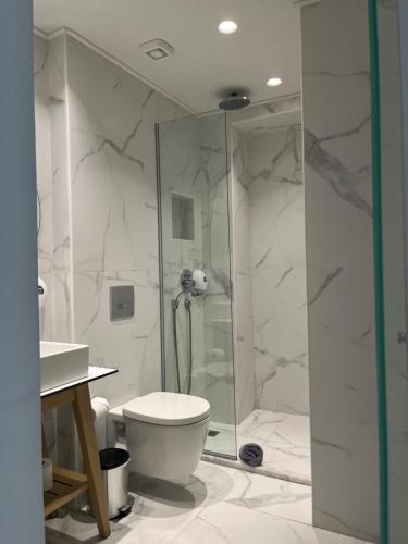 a white bathroom with a shower and a toilet at Maritime Suites in Hersonissos