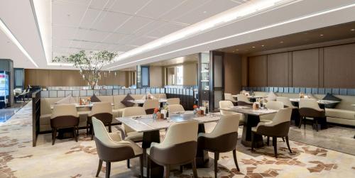 a restaurant with tables and chairs in a room at Yuexiu Hotel Guangzhou,Curio Collection by Hilton-Free shuttle between hotel and Exhibition Center during Canton Fair & Exhibitor Registration Counter in Guangzhou