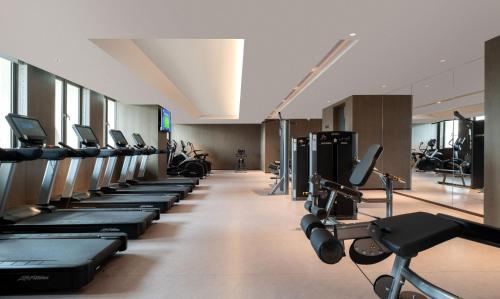 a gym with a row of treadms and machines at Yuexiu Hotel Guangzhou,Curio Collection by Hilton-Free shuttle between hotel and Exhibition Center during Canton Fair & Exhibitor Registration Counter in Guangzhou