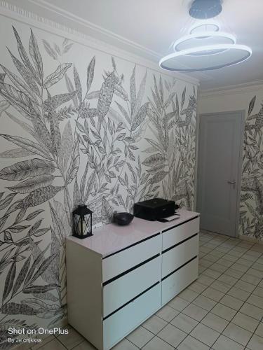 La salle de bains est pourvue d'une fresque murale représentant des plantes. dans l'établissement Belle chambre d'hôte avec balcon privé - 3 mins gare Annemasse - Genève accès direct, à Annemasse