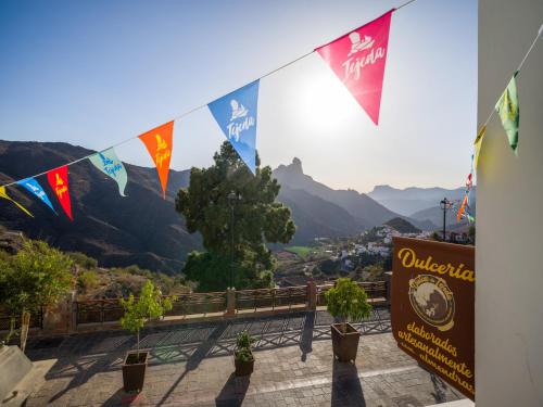 a sign with flags and a view of a mountain at Texeda Room Suites in Tejeda