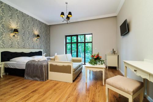 a bedroom with a bed and a couch at Pałac Margot Nature&SPA in Karpacz