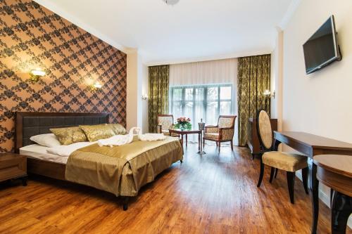 a hotel room with a bed and a desk at Pałac Margot Nature&SPA in Karpacz