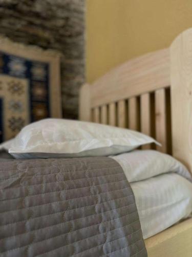 a bed with two pillows on top of it at Guesthouse Divo Hut in Ushguli