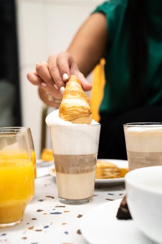 a person holding a sandwich in a cup on a table at Graphik Montparnasse in Paris
