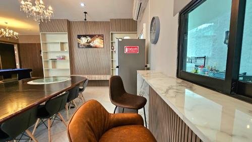 a kitchen with a bar with chairs and a refrigerator at PhuriPoolvilla ภูริพูลวิลล่า in Hang Dong