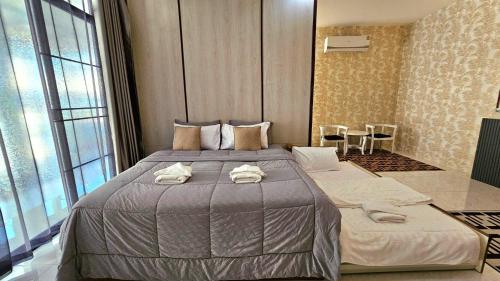 a bedroom with a large bed with towels on it at PhuriPoolvilla ภูริพูลวิลล่า in Hang Dong