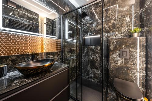 a black bathroom with a black bowl sink at Black Luxury Apartment in Janów