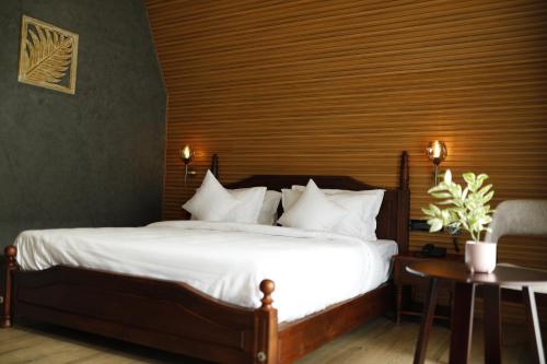 une chambre avec un grand lit avec des draps blancs dans l'établissement Leela's 7th Heaven Resort & Spa, à Turcunapulli