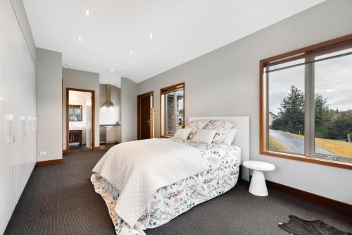 a bedroom with a bed and a large window at Studio Nestled in Ridgecrest in Wanaka