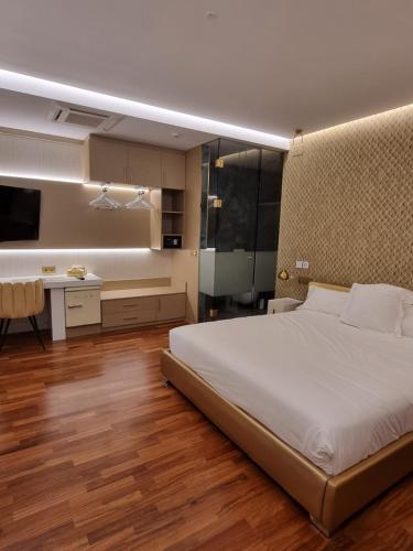 a bedroom with a large bed and a kitchen at Hotel Boutique Mirasierra in Villacañas