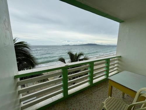 a balcony with a table and a view of the ocean at White Beach Hotel Puerto Galera powered by Cocotel in Puerto Galera
