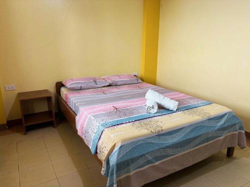 a bed with two towels on it in a room at White Beach Hotel Puerto Galera powered by Cocotel in Puerto Galera