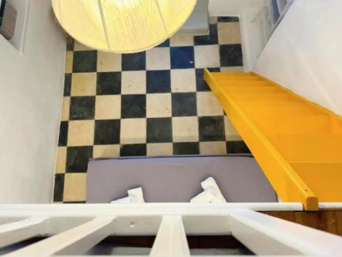 a room with a checkered floor and a wooden staircase at Bougainvillea Friends & Family Studio - Old Town in Mýkonos City