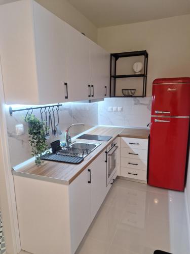 a kitchen with a red refrigerator and white cabinets at 9 keys boutique apartments in Orestiada