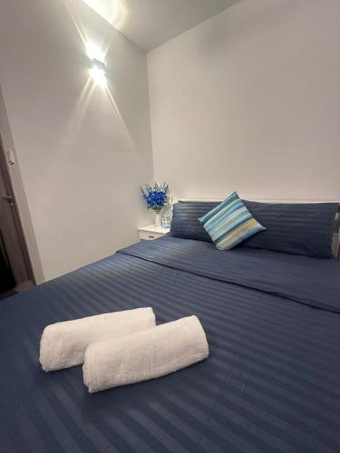 a bedroom with a blue bed with towels on it at Lilys By Dhalhey's in Hulhumale